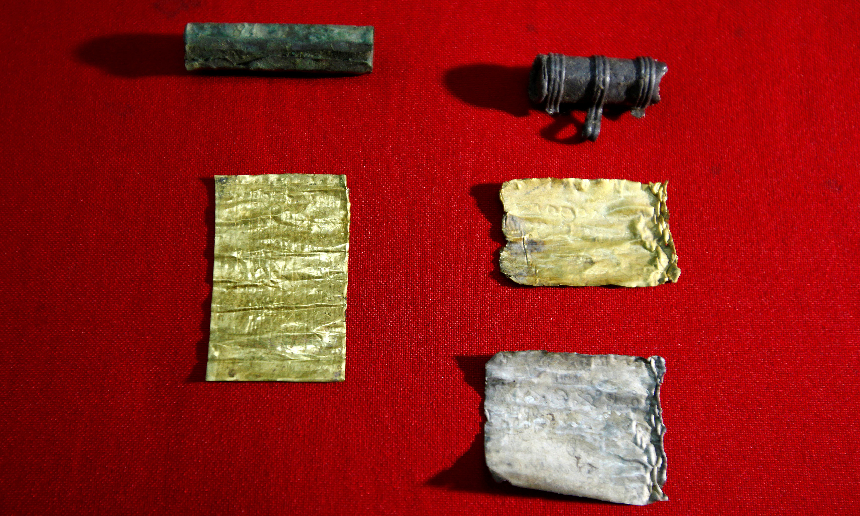 Two amulets with rolls of silver and gold  Photo by Djordje KojadinovicReuters 